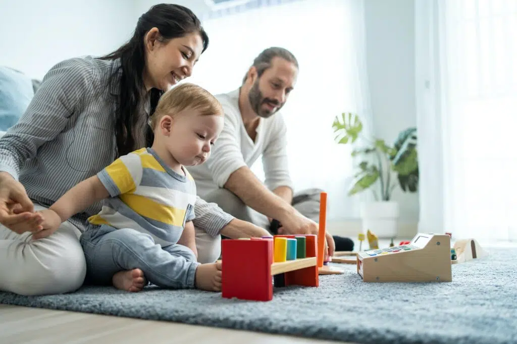 caucasian-happy-loving-parent-play-with-baby-toddler-in-living-room-.jpg